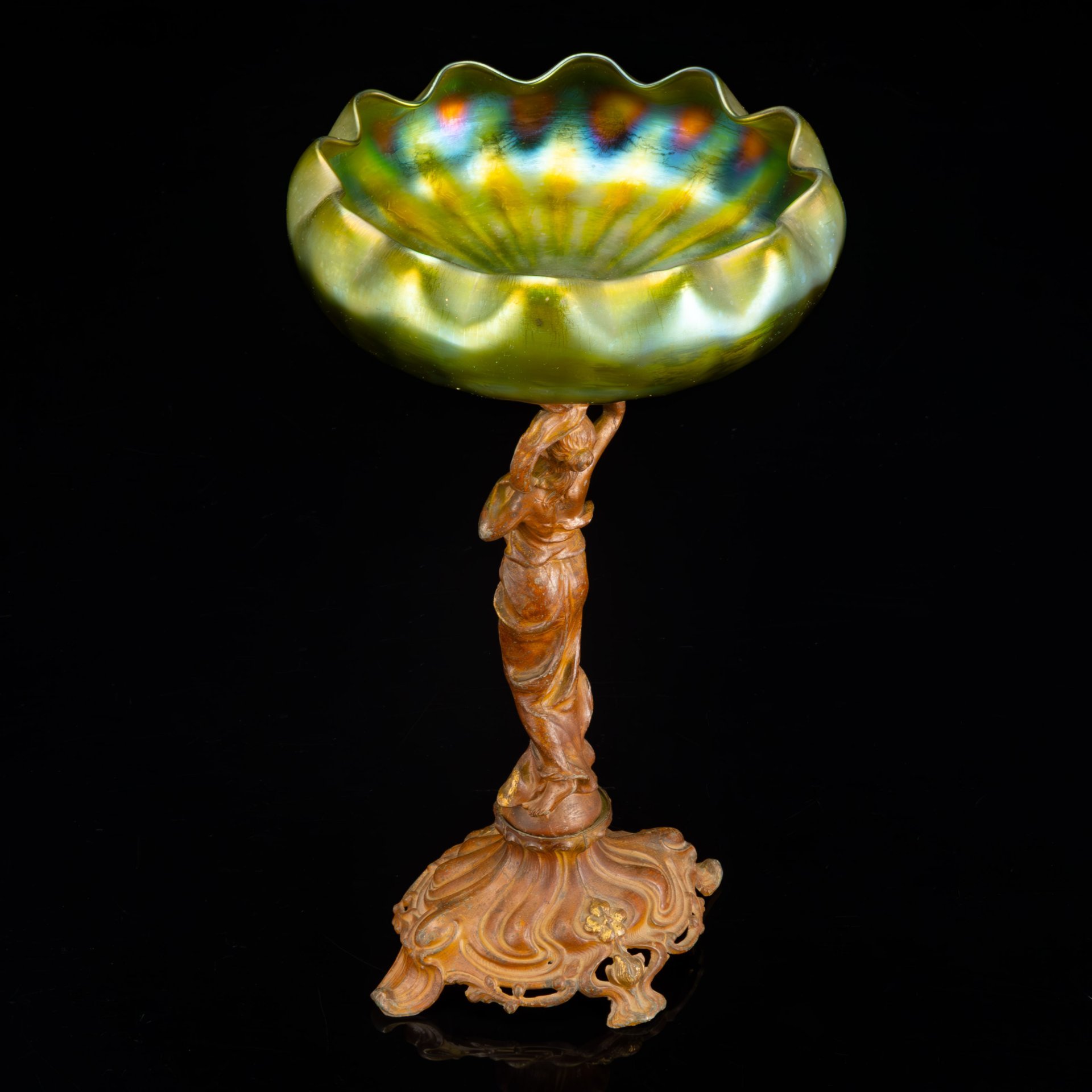 Фруктовница (ваза) в стиле модерн на фигурном основании в виде нимфы на шаре, которая держит чашу зеленоватого оттенка в виде раскрывающейся водяной лилии, loetz (?), металл, литье, формовка, стекло, гутная техника, иризация, Западная Европа, 1900-1920 гг.