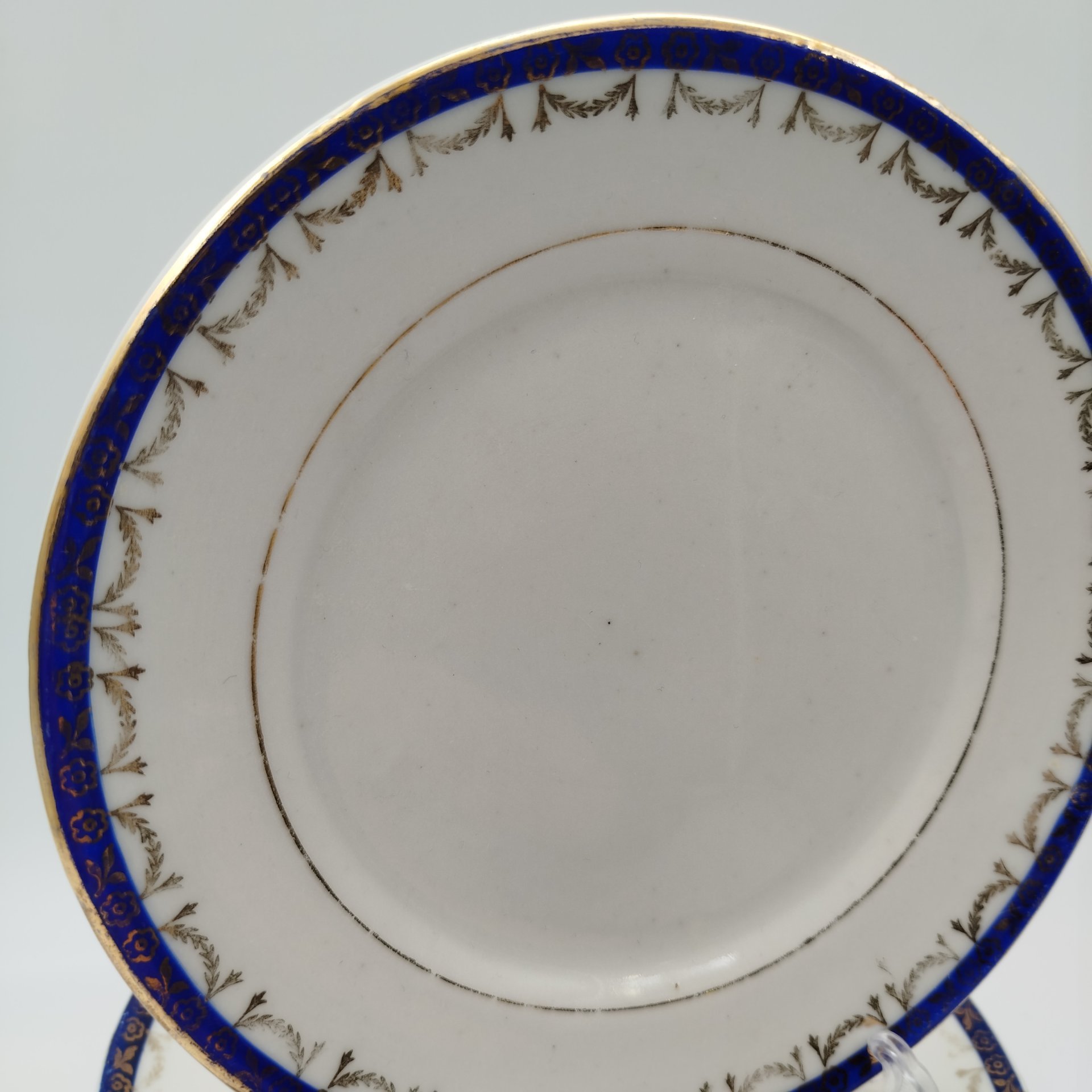 Набор из восьми десертных (закусочных) тарелок с орнаментальной каймой, клеймо «Новгубфарфор», фарфор, обводка, золочение, Завод «Красный фарфорист» (Чудово, Грузинская фарфорово-фаянсовая фабрика), СССР, 1923-1927 гг.