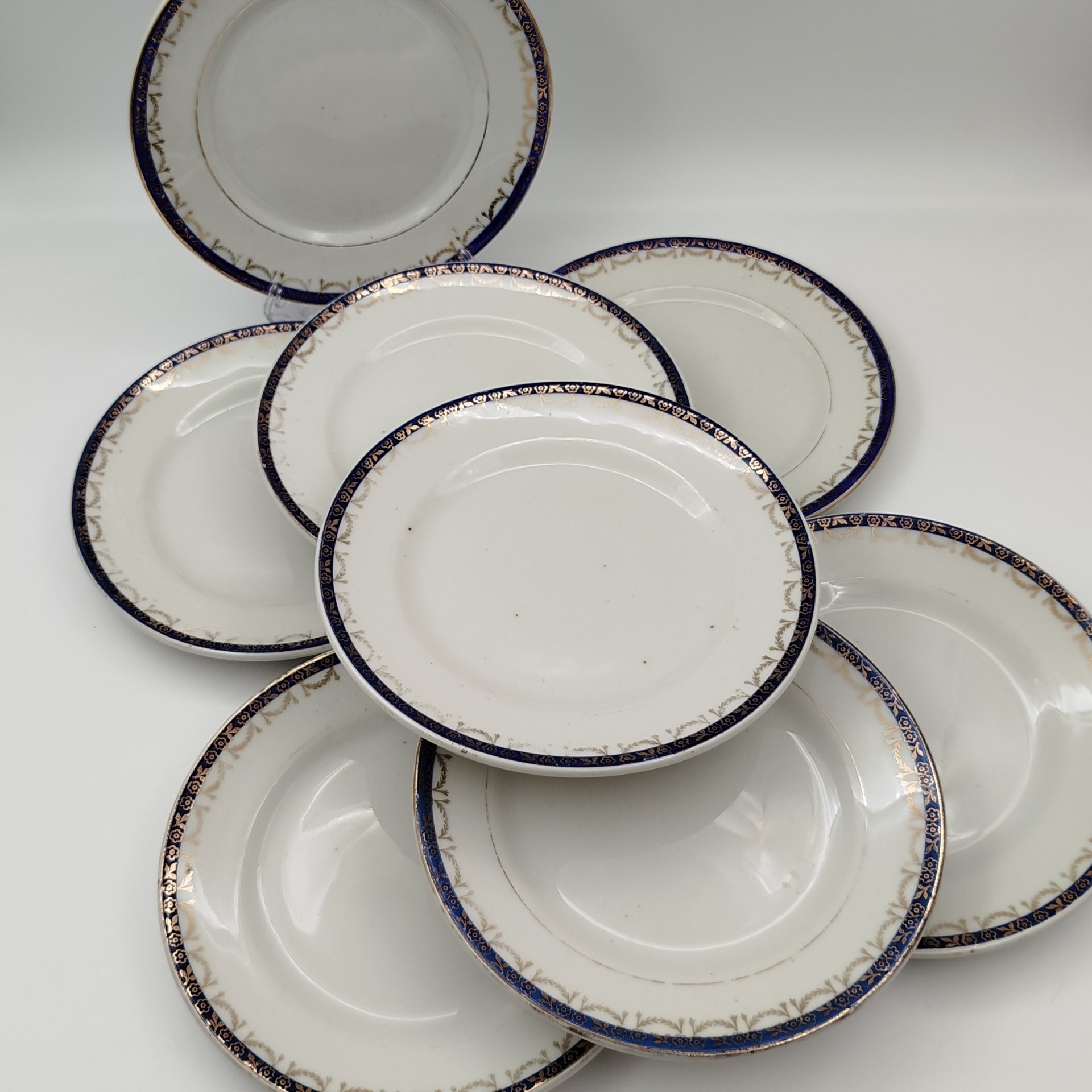 Набор из восьми десертных (закусочных) тарелок с орнаментальной каймой, клеймо «Новгубфарфор», фарфор, обводка, золочение, Завод «Красный фарфорист» (Чудово, Грузинская фарфорово-фаянсовая фабрика), СССР, 1923-1927 гг.