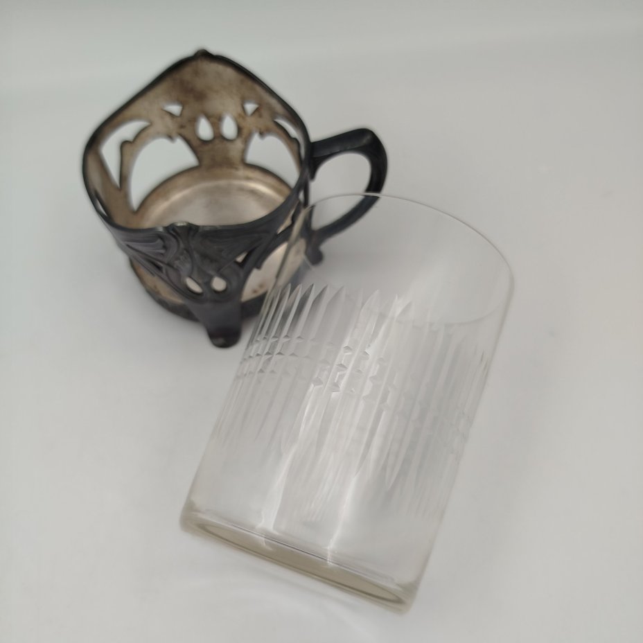 Подстаканник в стиле модерн с прорезным туловом и растительным декором (в комплекте со стаканом с геометрическим декором), металл, серебрение, стекло, Plewkiewicz & Co. (Фабрика Романа Плевкевича), Царство Польское, 1886-1914 гг.