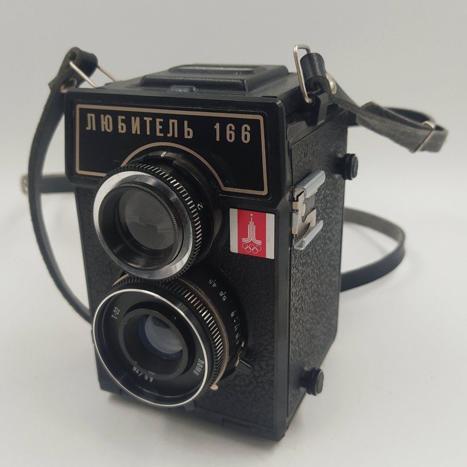 Фотоаппарат "Любитель-166" с олимпийской символикой, в чехле, металл, пластик, стекло, искусственная кожа, ЛОМО (Ленинградское оптико-механическое объединение), СССР, 1980 г., ЛОМО (Ленинградское оптико-механическое объединение)