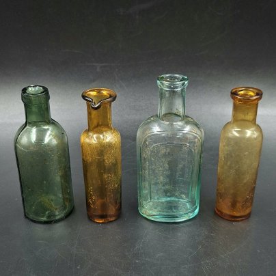 Набор из четырех флаконов различных форм и цветов