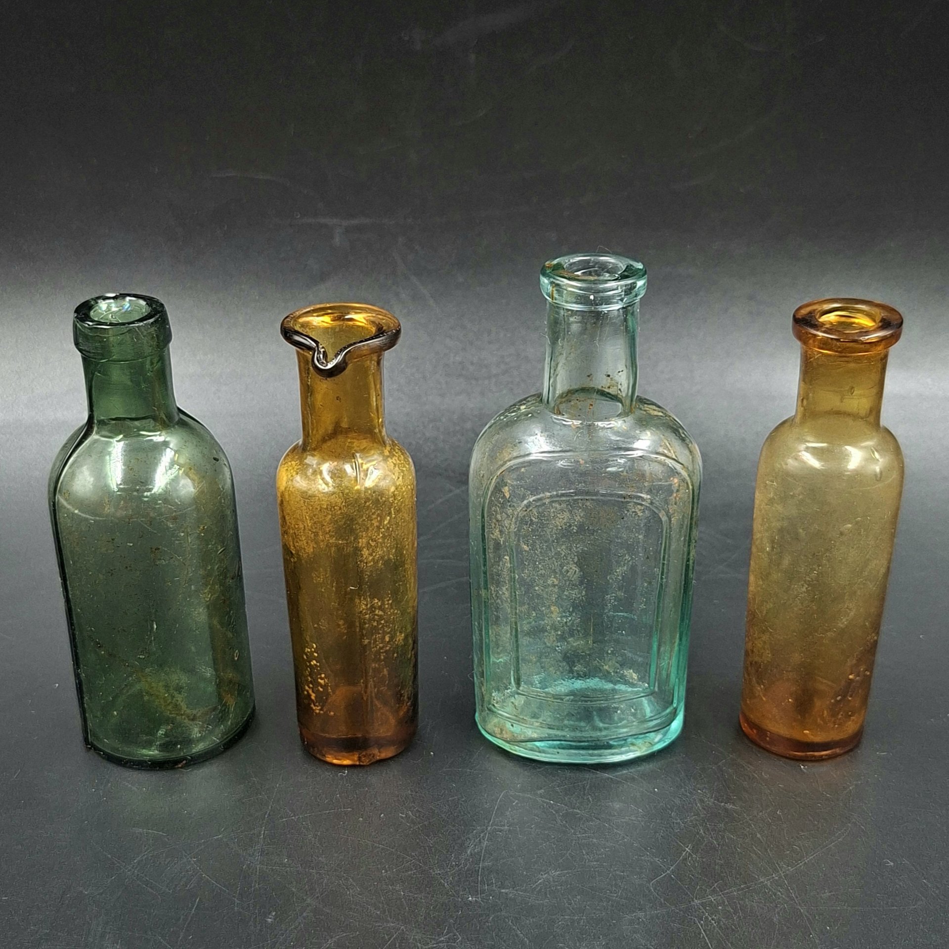 Набор из четырех флаконов различных форм и цветов