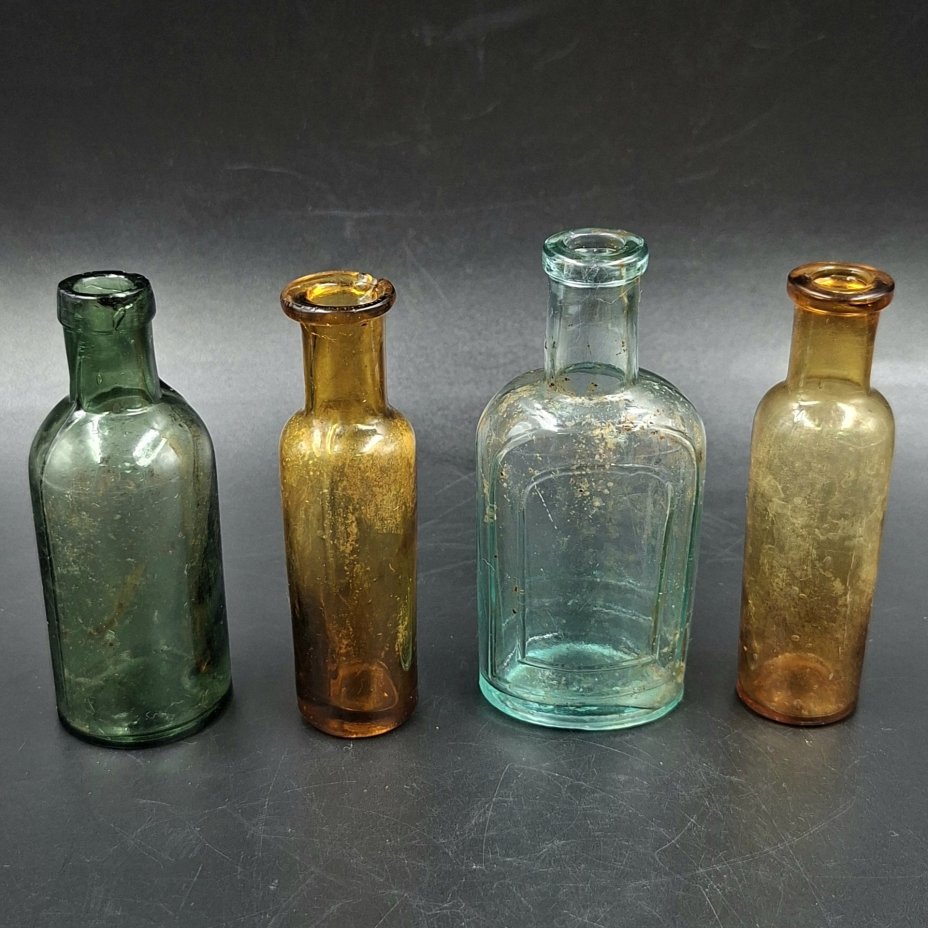 Набор из четырех флаконов различных форм и цветов