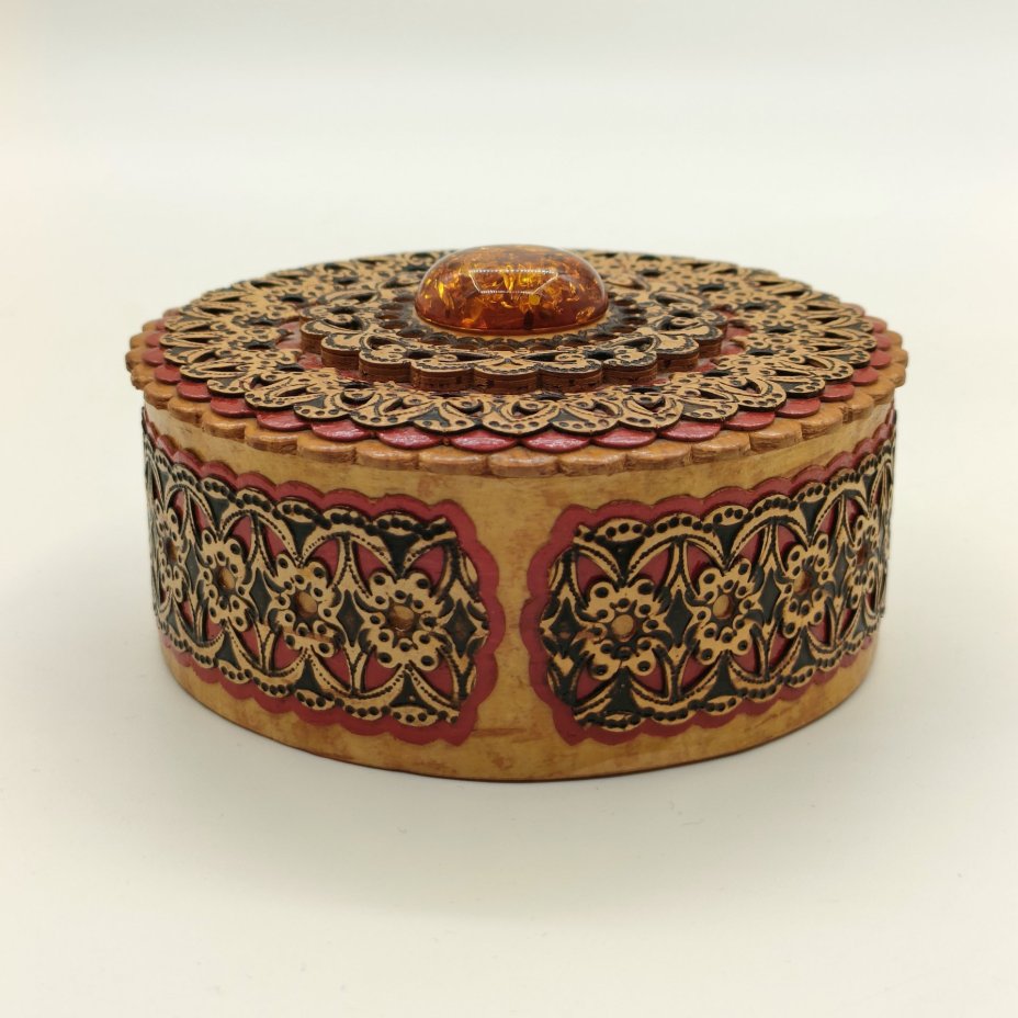 Шкатулка круглой формы в русском стиле, украшенная янтарного цвета вставкой и орнаментальным декором
