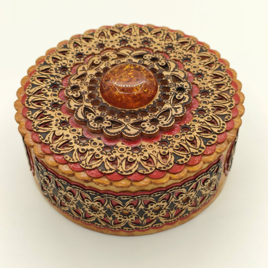 Шкатулка круглой формы в русском стиле, украшенная янтарного цвета вставкой и орнаментальным декором