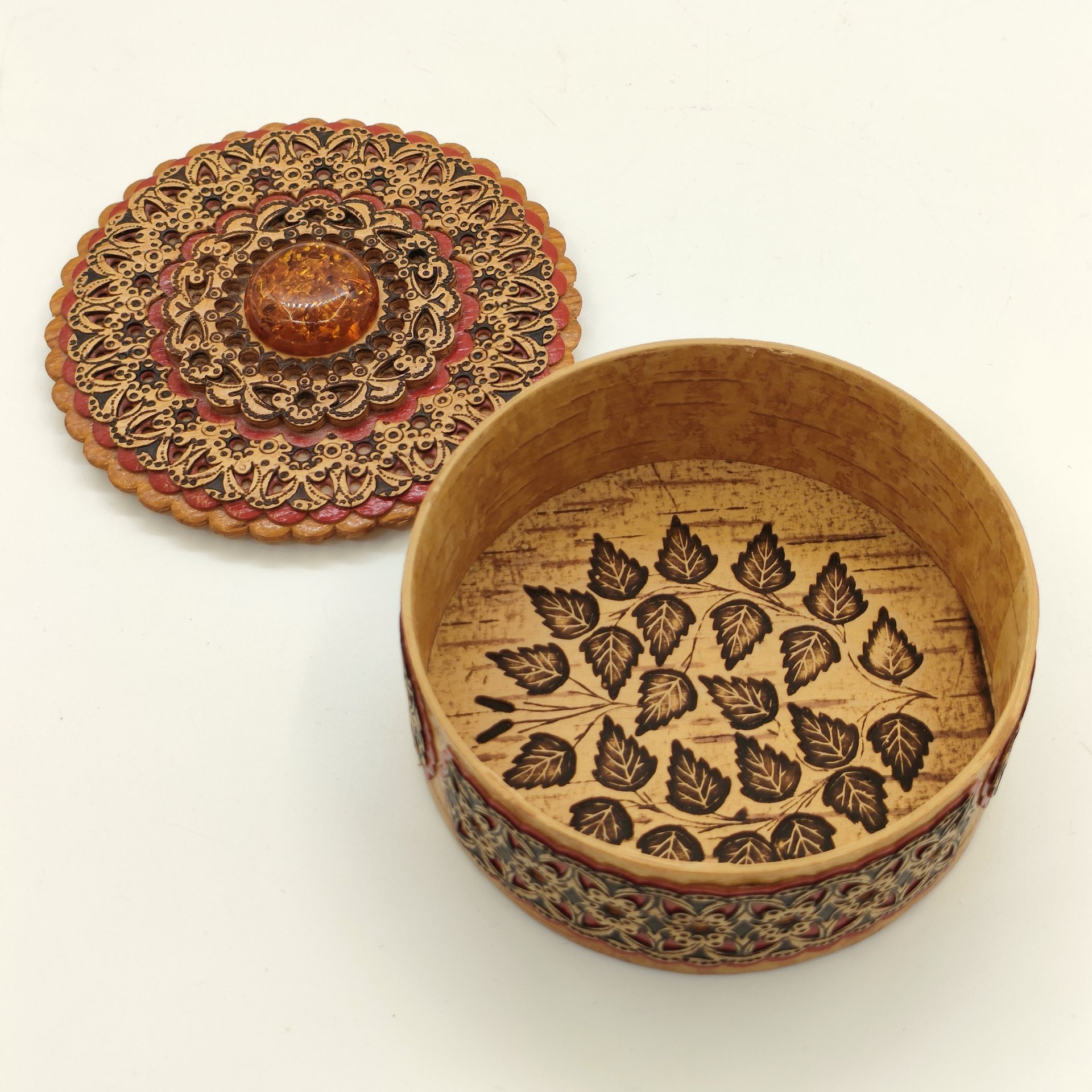 Шкатулка круглой формы в русском стиле, украшенная янтарного цвета вставкой и орнаментальным декором, дерево, береста, выжигание, резьба, краска, лак, Российская Федерация, 2000-2020 гг.