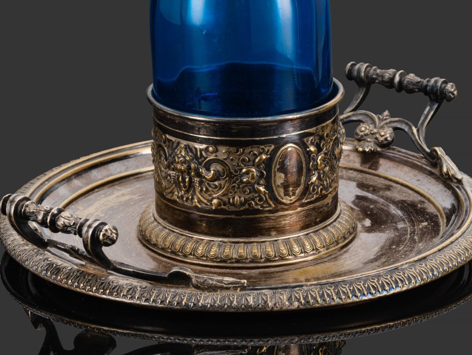 Подставка-передача для бутылки, декорированная маскаронами и флоральными мотивами, металл, гальваническое серебрение, купоросное стекло, Norblin & Co (Норблин), Царство Польское, 1872-1882 гг.