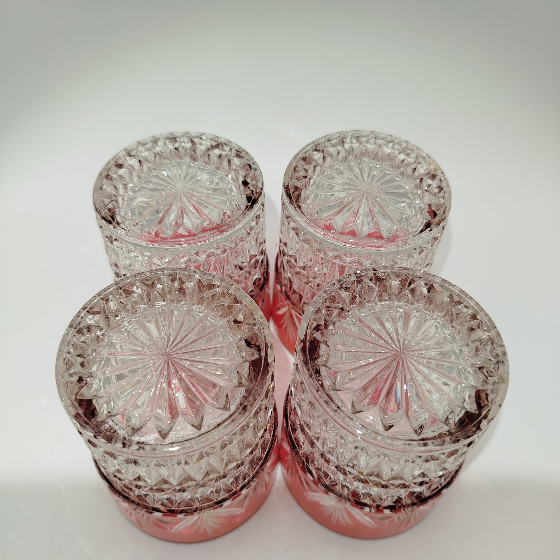 Набор из четырех стаканов с рельефным декором и верхней частью малинового оттенка с растительным орнаментом, стекло, нацвет, СССР, 1950-1980 гг.