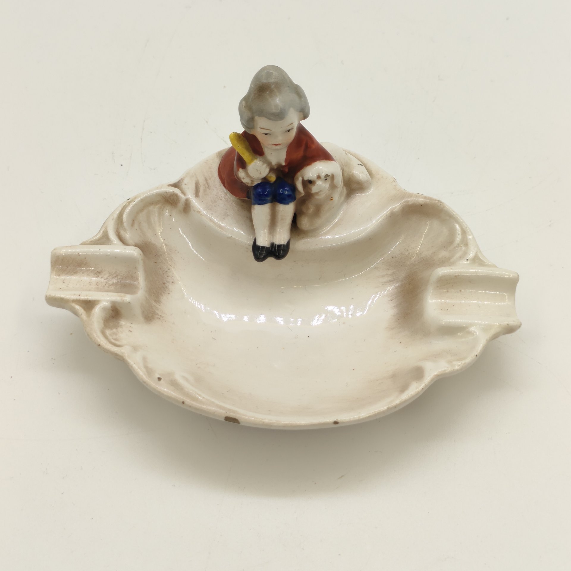 Пепельница с рельефным декором, украшенная фигуркой мальчика с собакой