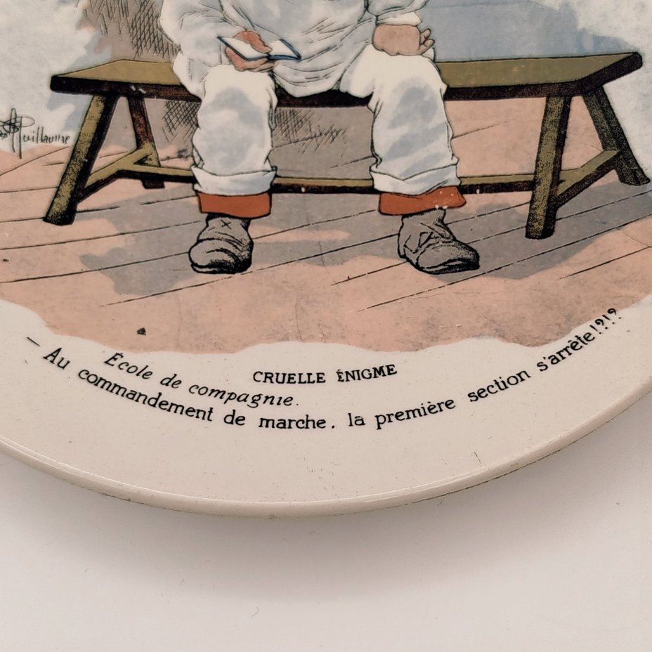 Тарелка декоративная "Cruelle Enigme. Ecole de compagnie.  Au commandement de marche, la premiere section s'arrete!?" ("Жестокая загадка. Школа роты. По команде к маршу первый отряд останавливается!?"), с подписью автора рисунка, фаянс, деколь, Sarreguemines (Саргемин), Франция, 1890-1920 гг.