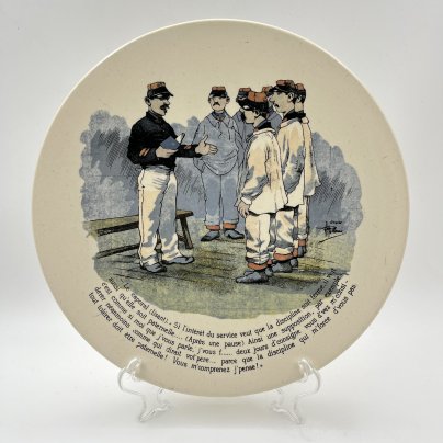Тарелка декоративная "Le caporal (lisant). "Si l'interet du service veut que la discipline soit ferme, il veit aussi qu'elle paternelle..." ("Капрал (читает): «Если интересы службы требуют строгой дисциплины, то она также требует отеческого отношения…"), фаянс, деколь, Sarreguemines (Саргемин), Франция, 1890-1920 гг.