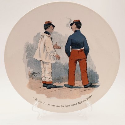 Тарелка декоративная с изображением двух солдат "Je m'en f... je m'en lave les mains comme Alphonse Pilate!" ("Мне плевать... Я умываю руки, как Альфонс Пилат!"), с подписью автора рисунка, фаянс, деколь, Sarreguemines (Саргемин), Франция, 1890-1920 гг.