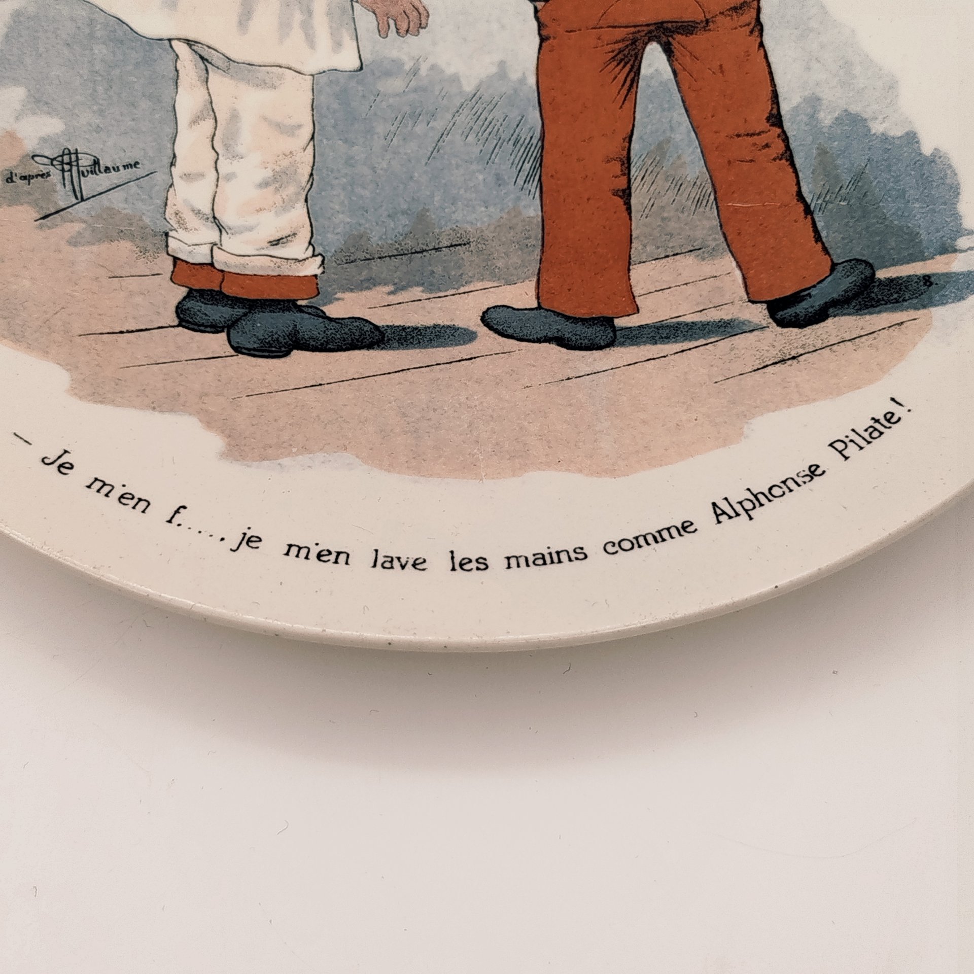 Тарелка декоративная с изображением двух солдат "Je m'en f... je m'en lave les mains comme Alphonse Pilate!" ("Мне плевать... Я умываю руки, как Альфонс Пилат!"), с подписью автора рисунка, фаянс, деколь, Sarreguemines (Саргемин), Франция, 1890-1920 гг.