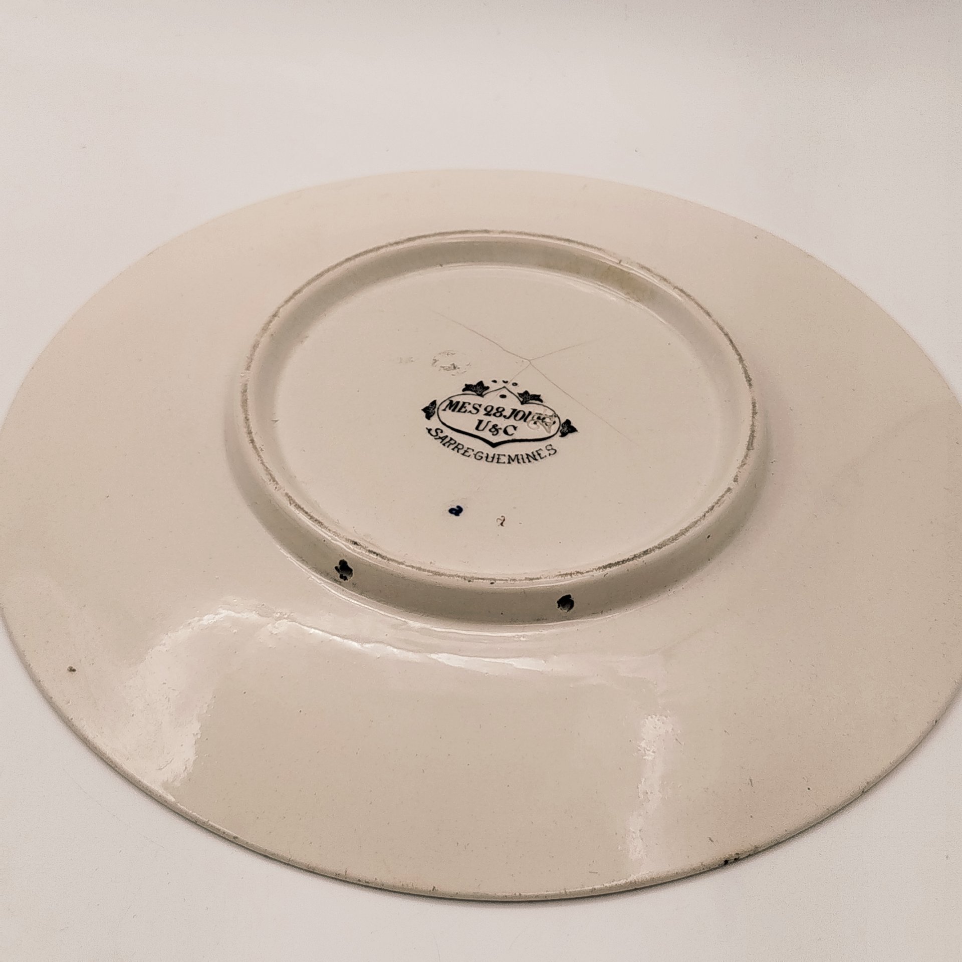 Тарелка декоративная с изображением двух солдат "Je m'en f... je m'en lave les mains comme Alphonse Pilate!" ("Мне плевать... Я умываю руки, как Альфонс Пилат!"), с подписью автора рисунка, фаянс, деколь, Sarreguemines (Саргемин), Франция, 1890-1920 гг.