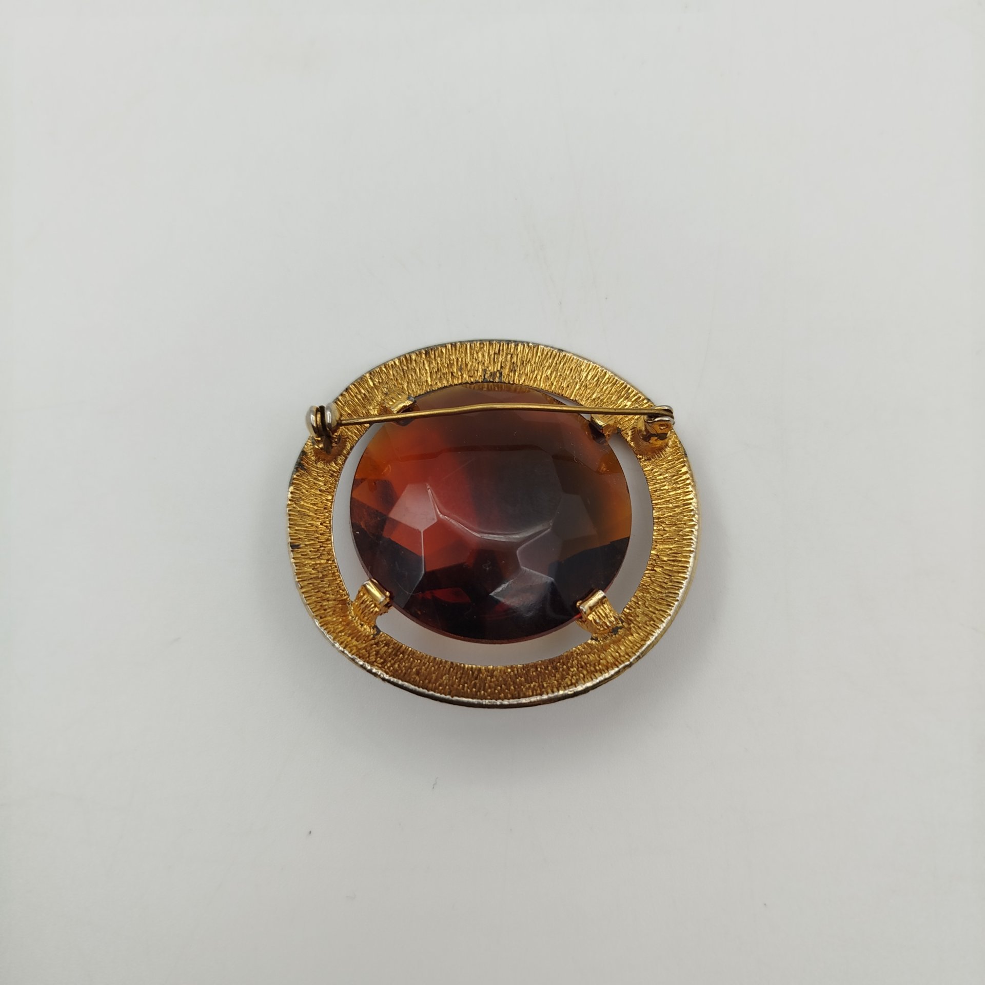 Брошь круглой формы, со вставкой коричневого цвета, металл, стекло, золочение, СССР, 1970-1980 гг.