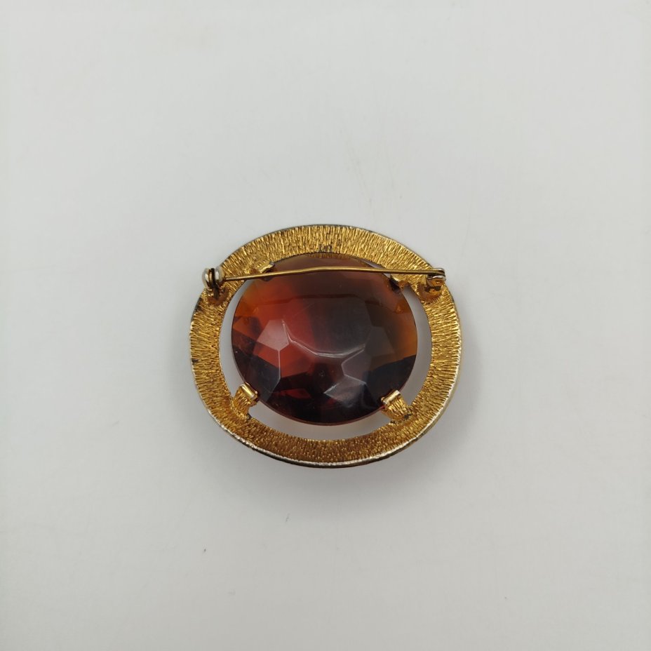 Брошь круглой формы, со вставкой коричневого цвета