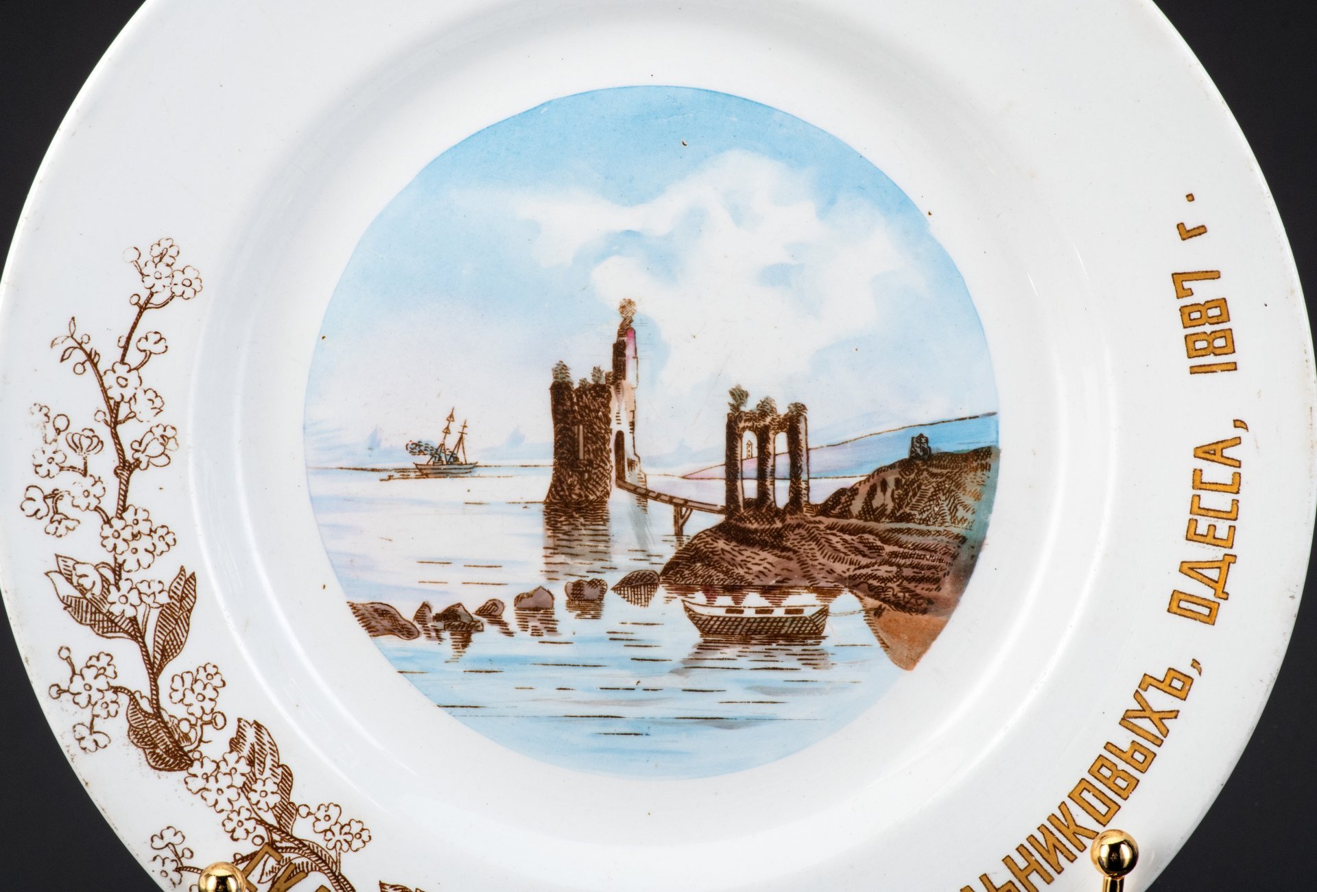 Тарелка декоративная с владельческой надписью и деколью: "Скала "Пушкина", дача Мельниковых, Одесса, 1887 г." и вензелем "М", фаянс, деколь, золочение, Товарищество М.С. Кузнецова в Твери, Российская империя, 1870-1889 гг.